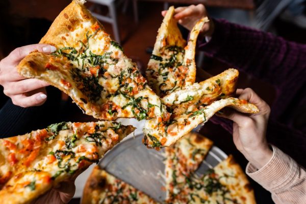 Hands grabbing pizza slices